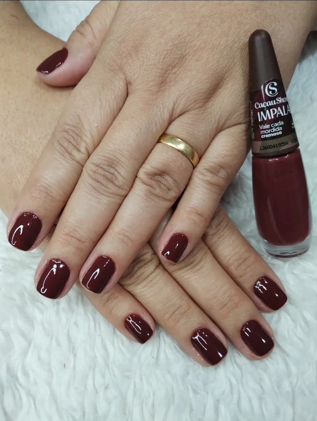 Unhas esmaltadas em tom vinho
