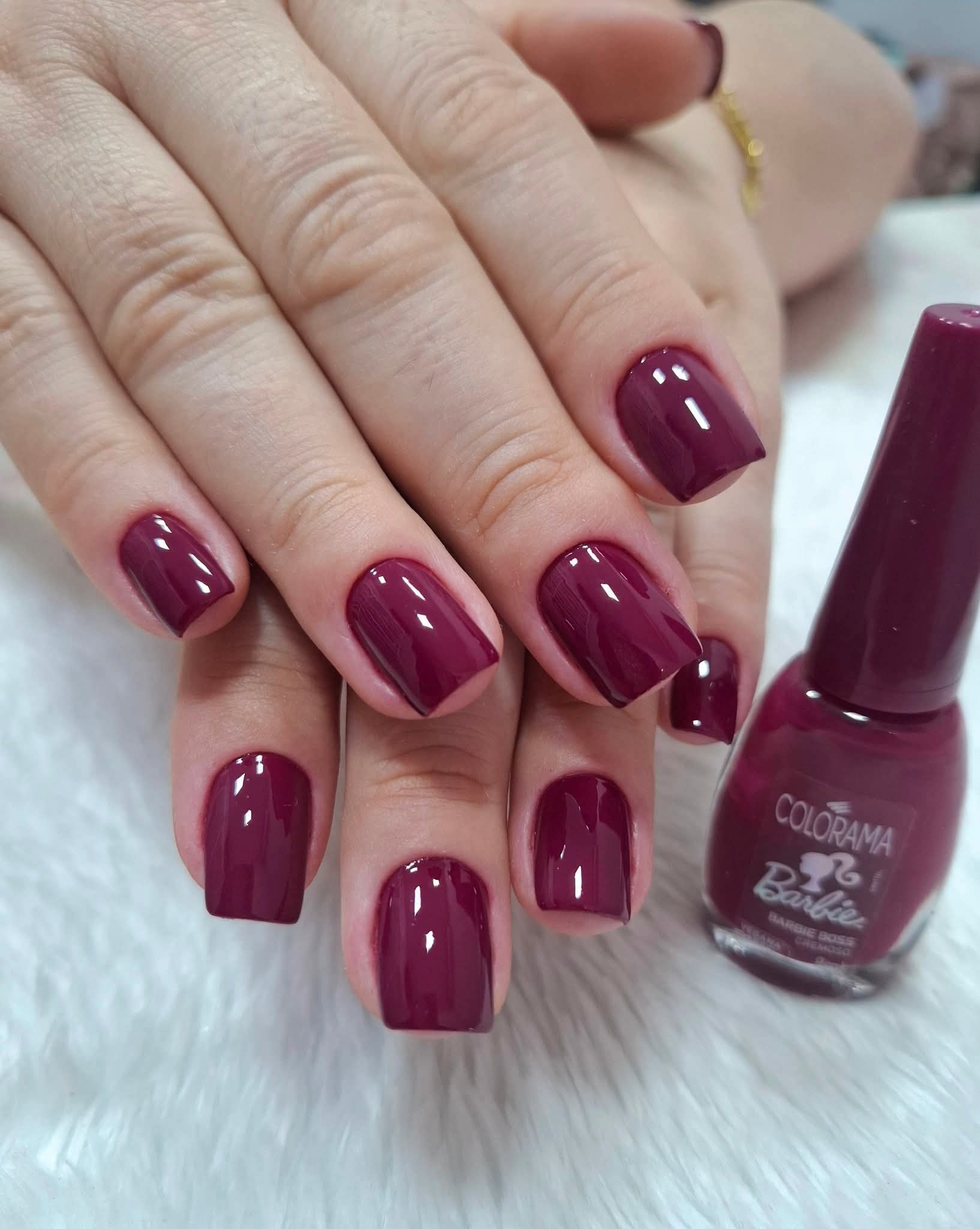 Unhas esmaltadas em tom magenta